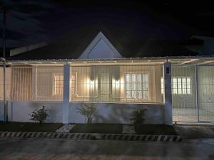 ein Haus in der Nacht mit eingeschaltetem Licht in der Unterkunft Japandi Home C - Fully Aircon, WIFI, Hot shower, 24hGuard, Center, near Malls in General Santos