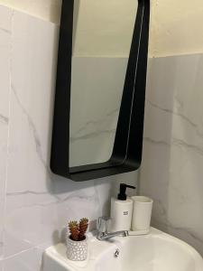 W łazience znajduje się umywalka z lustrem i umywalka. w obiekcie Japandi Home C - Fully Aircon, WIFI, Hot shower, 24hGuard, Center, near Malls w mieście General Santos