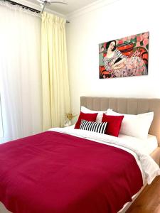 - une chambre avec un lit rouge orné d'une peinture murale dans l'établissement Amani Apart, à Almaty