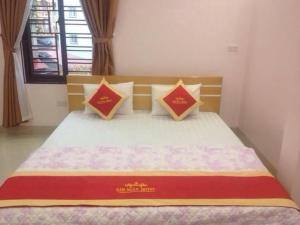 una camera da letto con un letto con cuscini rossi e gialli di Kim Ngân Hotel Lào Cai a Lao Cai