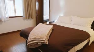 Un dormitorio con una cama grande con una almohada. en Murmure　6人家族や友人向け　ペット可, en Tsumagoi