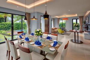 Best Western Premier Sonasea Villas Phu Quoc في فو كووك: غرفة طعام وغرفة معيشة مع طاولة وكراسي
