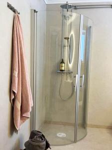 a shower with a glass door in a bathroom at Charming cottage in Forsa, Hudiksvall with lake view in Hudiksvall