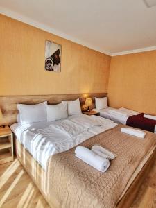 a bedroom with two beds with towels on them at Sunshine Kazbegi in Stepantsminda