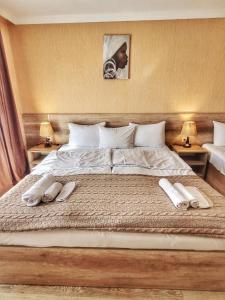 a bedroom with a large bed with two towels on it at Sunshine Kazbegi in Stepantsminda