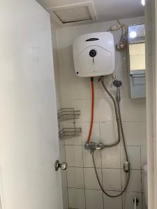 a shower in a bathroom with a white tank at Capital O 93730 Alima View Syariah in Bekasi
