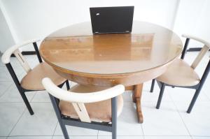 a glass table with a laptop on top of it at OYO 93710 Bidara Guest House Syariah in Mojokerto