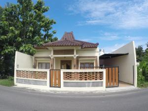 una piccola casa bianca con una recinzione in legno di Capital O 93718 Homestay 3 Bidadari a Yogyakarta