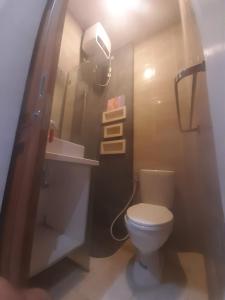 a bathroom with a white toilet and a sink at Capital O 93718 Homestay 3 Bidadari in Yogyakarta