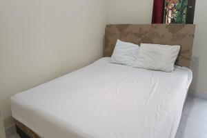 庫塔的住宿－SPOT ON 93724 Songgong Homestay，一张白色的床,上面有两个枕头