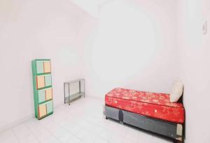 a room with a red couch and a shelf at OYO 93722 Shannhay Guest House in Jakarta