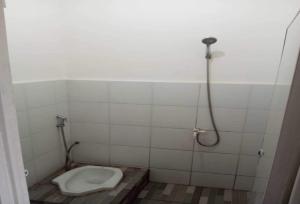 a bathroom with a toilet and a shower at OYO 93722 Shannhay Guest House in Jakarta