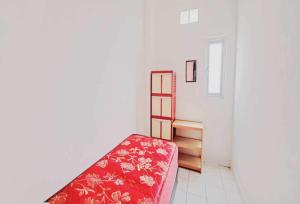 a room with a red bed and a stair case at OYO 93722 Shannhay Guest House in Jakarta