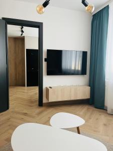 een woonkamer met een grote spiegel en een tv bij APARTMÁN STYLE Brezno in Brezno +19 foto's