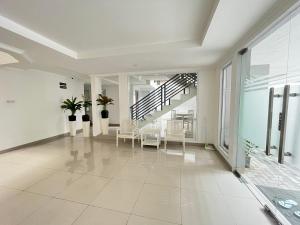 a large white hallway with chairs and a staircase at OYO 93721 Pulo Asem Residence in Jakarta