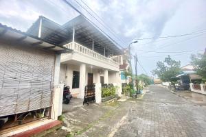 an empty street in front of a white house at SPOT ON 93717 Nayus Homestay Syariah 4 in Yogyakarta