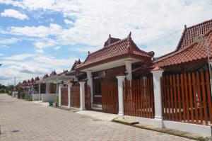 a row of buildings with red roofs on a street at Capital O 93719 Homestay Omah Bidadari in Prambanan