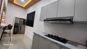 a kitchen with a stove and a counter top at Capital O 93719 Homestay Omah Bidadari in Prambanan