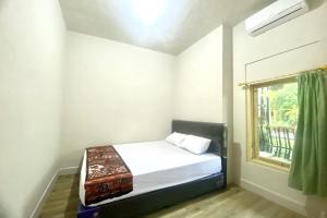 a small bedroom with a bed and a window at SPOT ON 93717 Nayus Homestay Syariah 4 in Yogyakarta