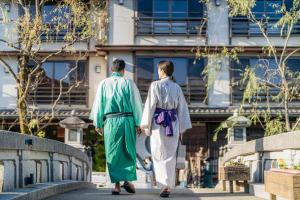 a man and a woman walking down a bridge at Shinzan Kinosaki in Toyooka