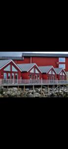 a red building with a train in front of it at Lofoten Rorbu - Odin bua in Stamsund