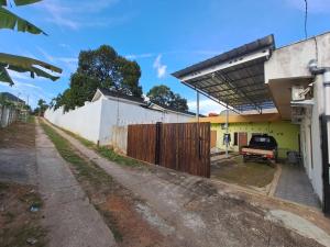 a house with a fence and a picnic table at OYO 93714 Guest House Gembul Syariah in Jambi