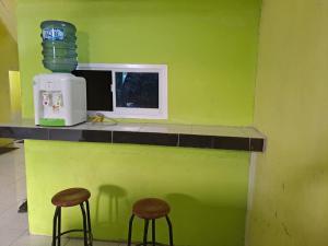 two stools sitting at a counter with a microwave at OYO 93714 Guest House Gembul Syariah in Jambi