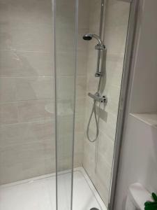 a shower with a glass door in a bathroom at Versace The Malt House in Burton upon Trent