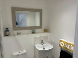 Baño blanco con lavabo y espejo en Versace The Malt House, en Burton upon Trent