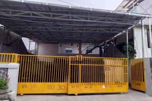 ein gelbes Tor vor einem Gebäude in der Unterkunft Capital O 93728 Guest House Cemara in Bandung