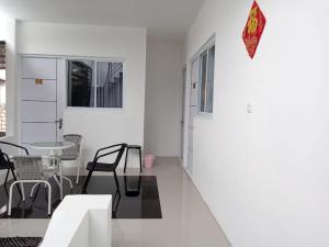 ein weißes Wohnzimmer mit einem Tisch und Stühlen in der Unterkunft Capital O 93728 Guest House Cemara in Bandung