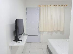 ein weißes Bad mit einem TV auf der Theke in der Unterkunft Capital O 93728 Guest House Cemara in Bandung