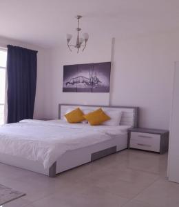 a bedroom with a bed with two yellow pillows at AL ALKEEM HEIGHTS in Ras al Khaimah