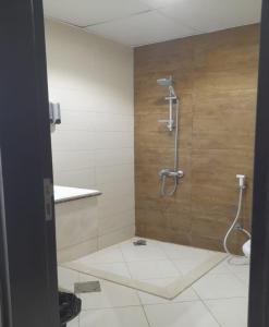 a bathroom with a shower with a wooden wall at AL ALKEEM HEIGHTS in Ras al Khaimah