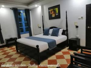 a bedroom with a large bed with blue pillows at Villa Merry Lao Ban Aphay in Luang Prabang