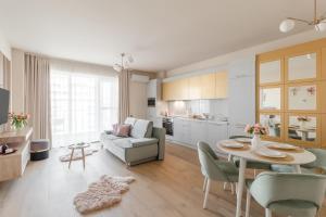 a kitchen and living room with a table and a couch at Chic Central Oradea in Oradea