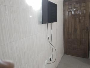 un televisor en una pared junto a una puerta en Mid Way Best Hotel, en Lagos