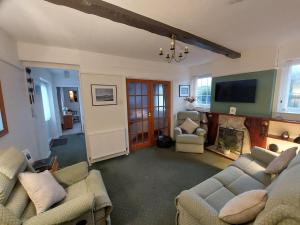 een woonkamer met 2 banken en een flatscreen-tv bij Private apartment, parking, sea and country views in Lyme Regis