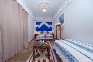 a bedroom with a bed and a table in it at Riad Amalia in Marrakech