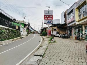 una strada vuota con un cartello sul lato della strada di Eleven Guest House Syariah a Sukaraja
