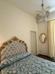 una camera con letto, specchio e lampadario a braccio di beb Mariafrancesca a Napoli