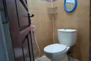 a bathroom with a toilet and a mirror at OYO 93756 Qq Kost in Laleng-balandae