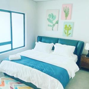 a blue and white bed in a room with a window at City Centre Hotel in Walvis Bay