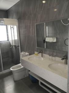 uma casa de banho com 2 lavatórios, um WC e um chuveiro em City Centre Hotel em Walvis Bay