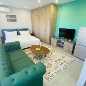 uma sala de estar com uma cama, um sofá e uma televisão em City Centre Hotel em Walvis Bay