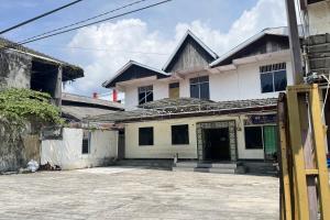 a white house with a courtyard in front of it at OYO 93752 Aglo Homestay in Rantau