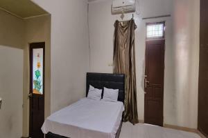 um quarto com uma cama, uma janela e uma porta em OYO 93752 Aglo Homestay em Rantau