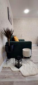 een woonkamer met een groene bank en een tafel bij Apartment Rustaveli 118 in Koetaisi