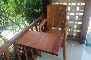 uma mesa e cadeira de madeira numa varanda em OYO 93737 Bale Oyan Homestay em Kuta Lombok