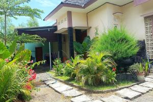 una casa con plantas delante de ella en OYO 93737 Bale Oyan Homestay en Kuta Lombok